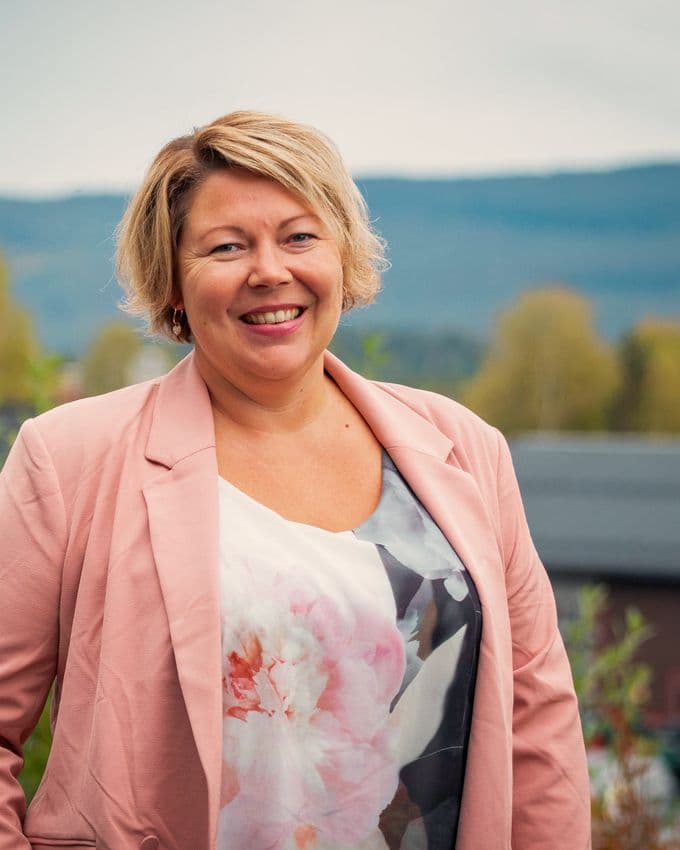 Inger Lene Bekkjorden, leder ved NAV Numedal, utendørs med åsene i Numedal i bakgrunnen.